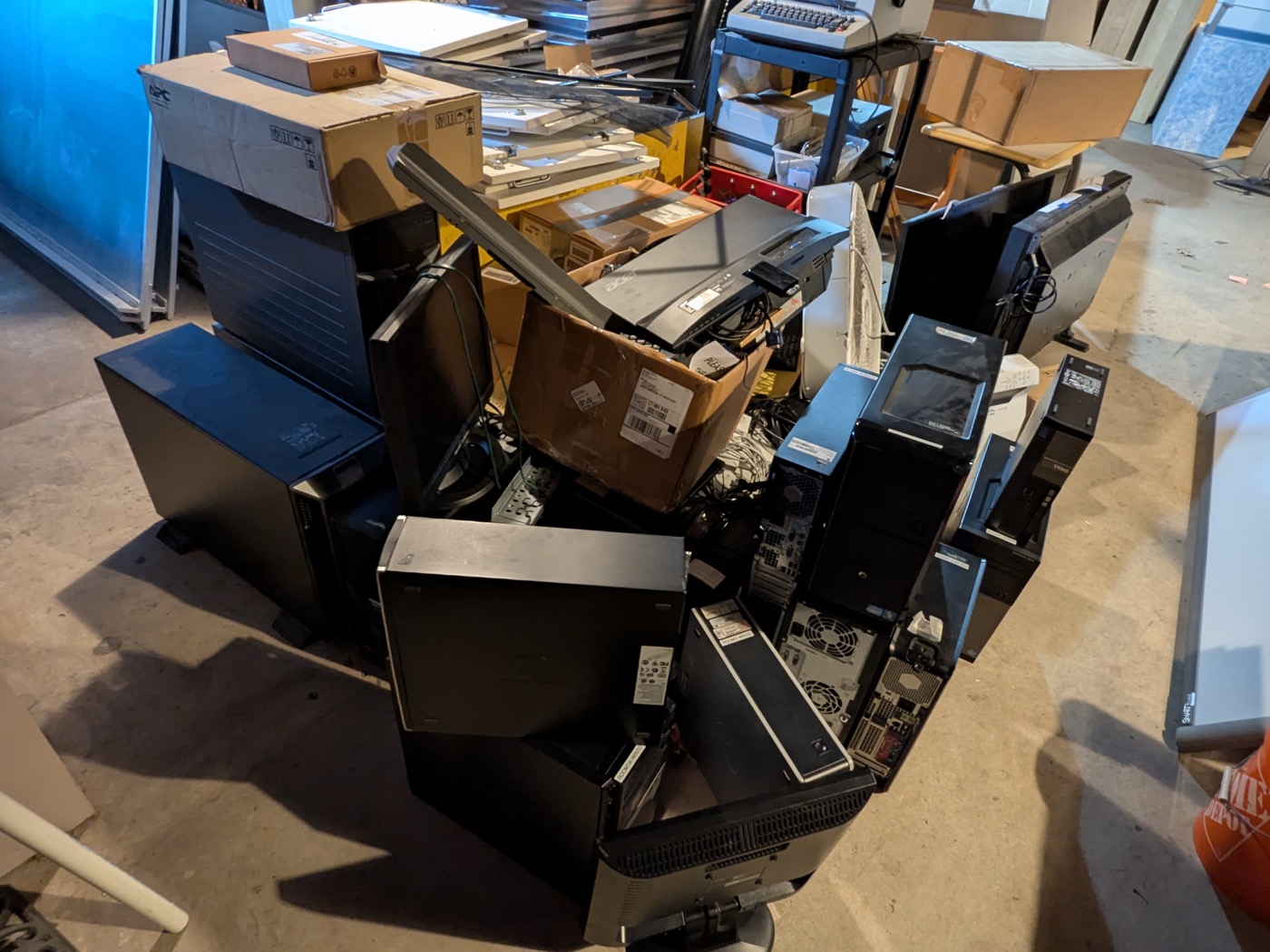 Mixed IT equipment cleanout with desktops, monitors, boxes, and accessories