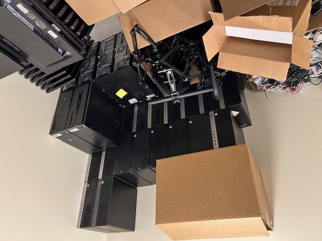 Client stock room stacked with retired desktops, cables, and boxes